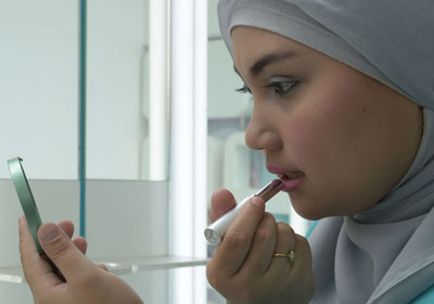 فتاه إندونيسية تضع الماكياج فى إعلان عن إحدى الماركات الإسلامية